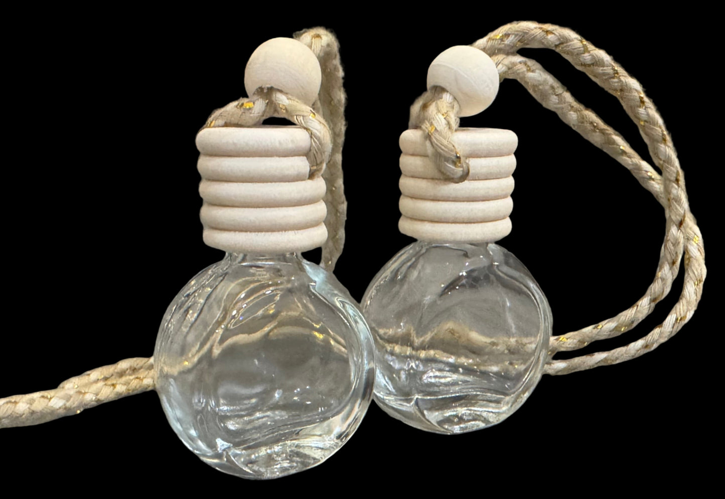 Two clear glass car diffuser bottles with ropes to hang car air fresheners.