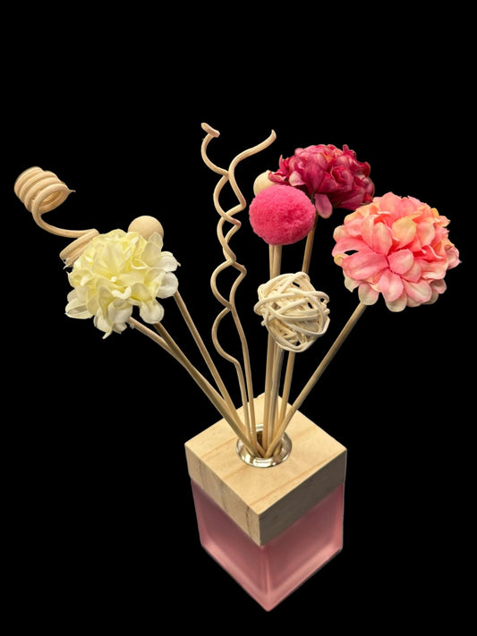 Decorative diffuser flower arrangement with pink flowers in an Amalthea diffuser bottle