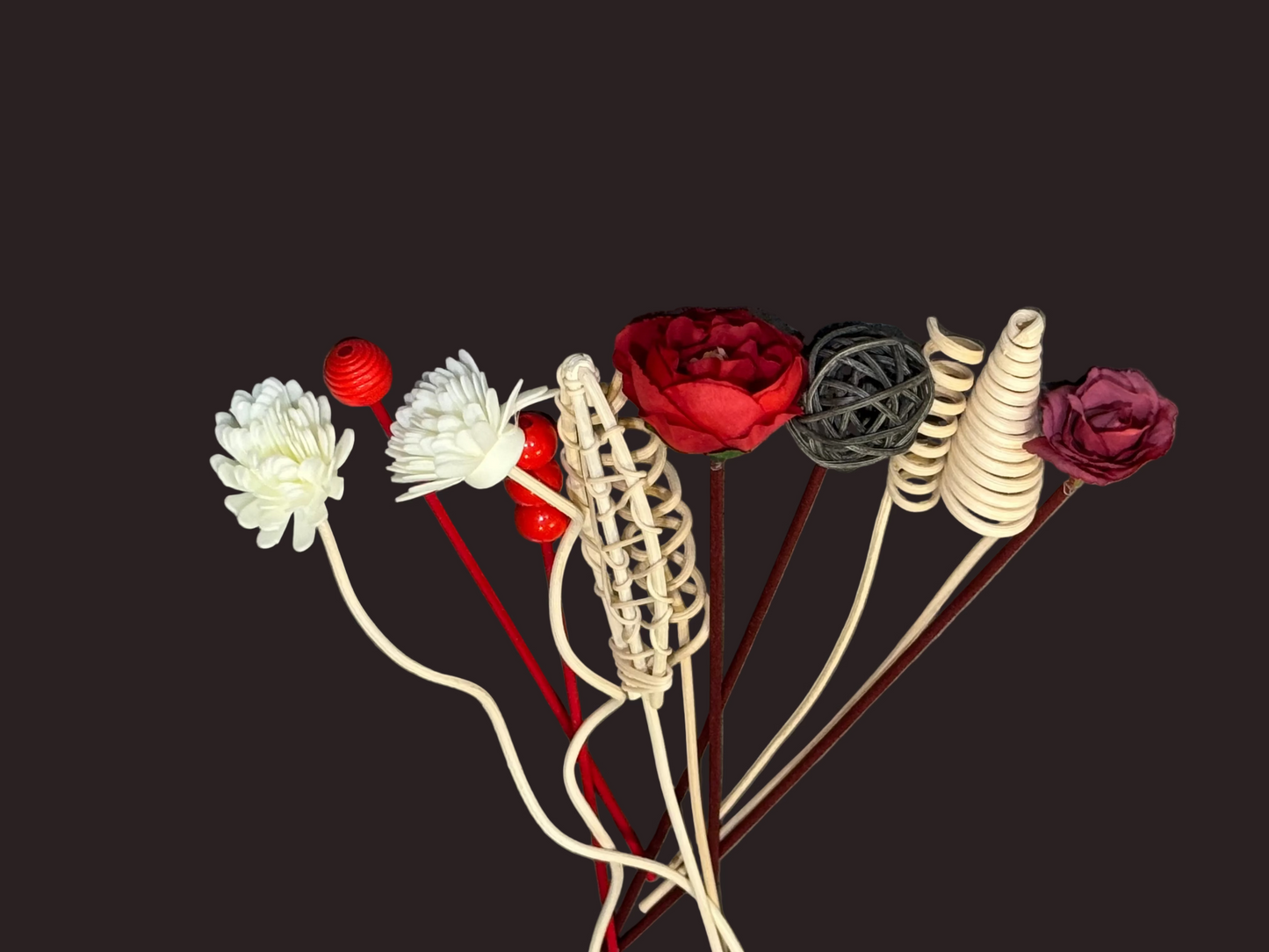 Decorative items including flowers and spherical ornaments for reed diffusers on a gray background