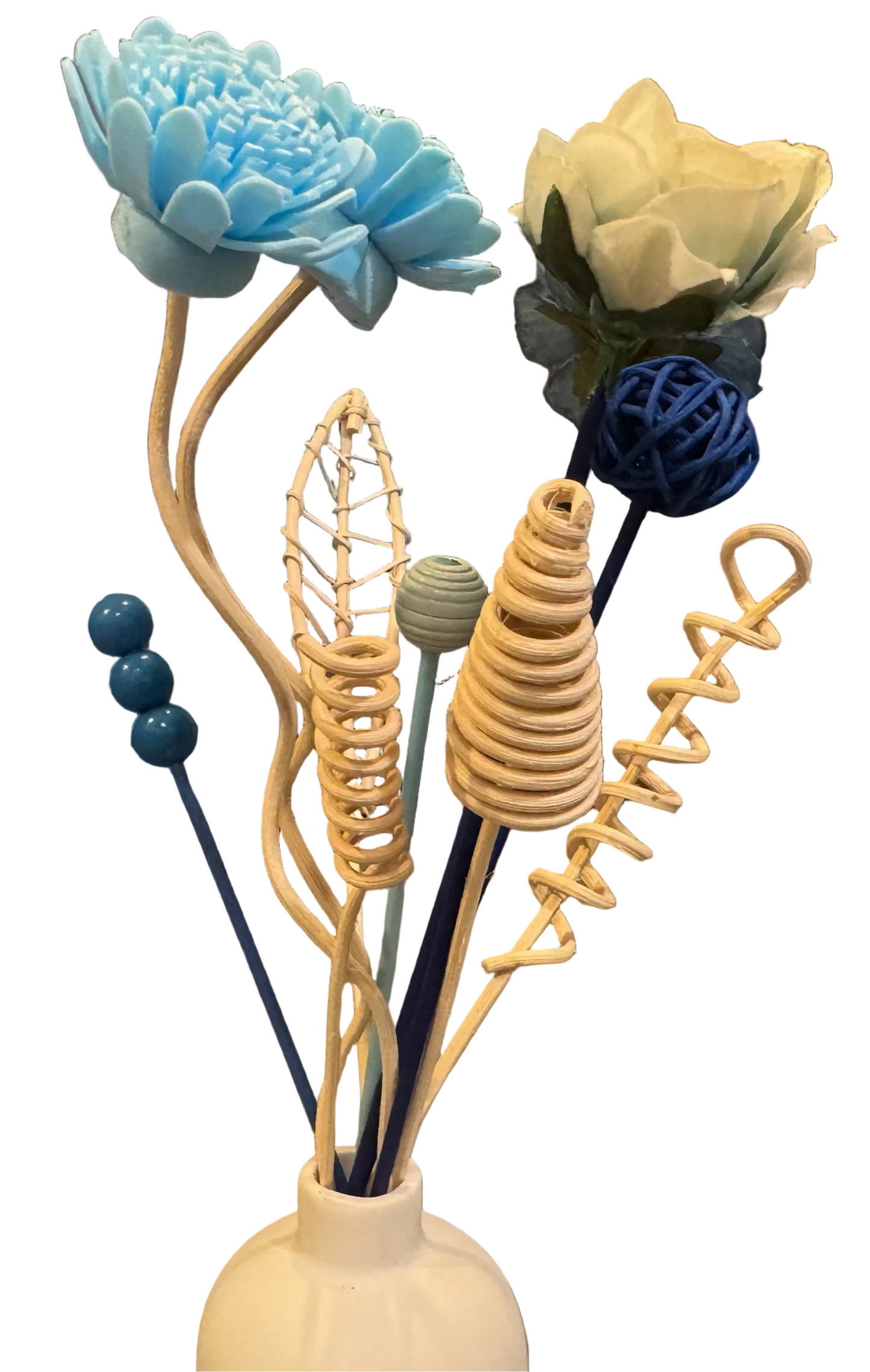 Decorative reed diffuser flower arrangement with blue, white, and beige flowers in a white vase on a table.