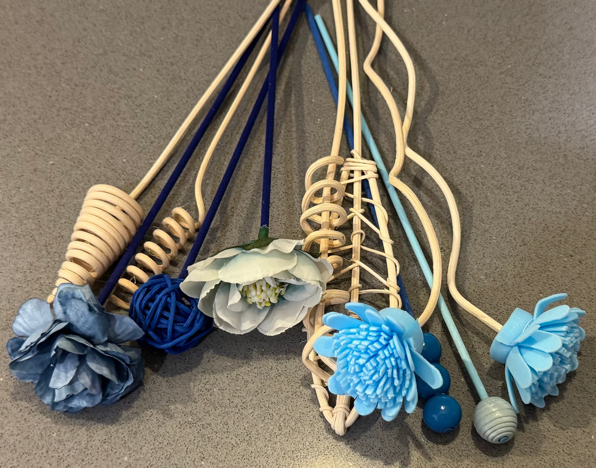 Decorative reed diffuser sticks with blue and white flower-like ends 