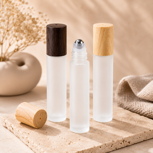 Three clear glass roller bottles with wooden and black caps on a wooden surface.