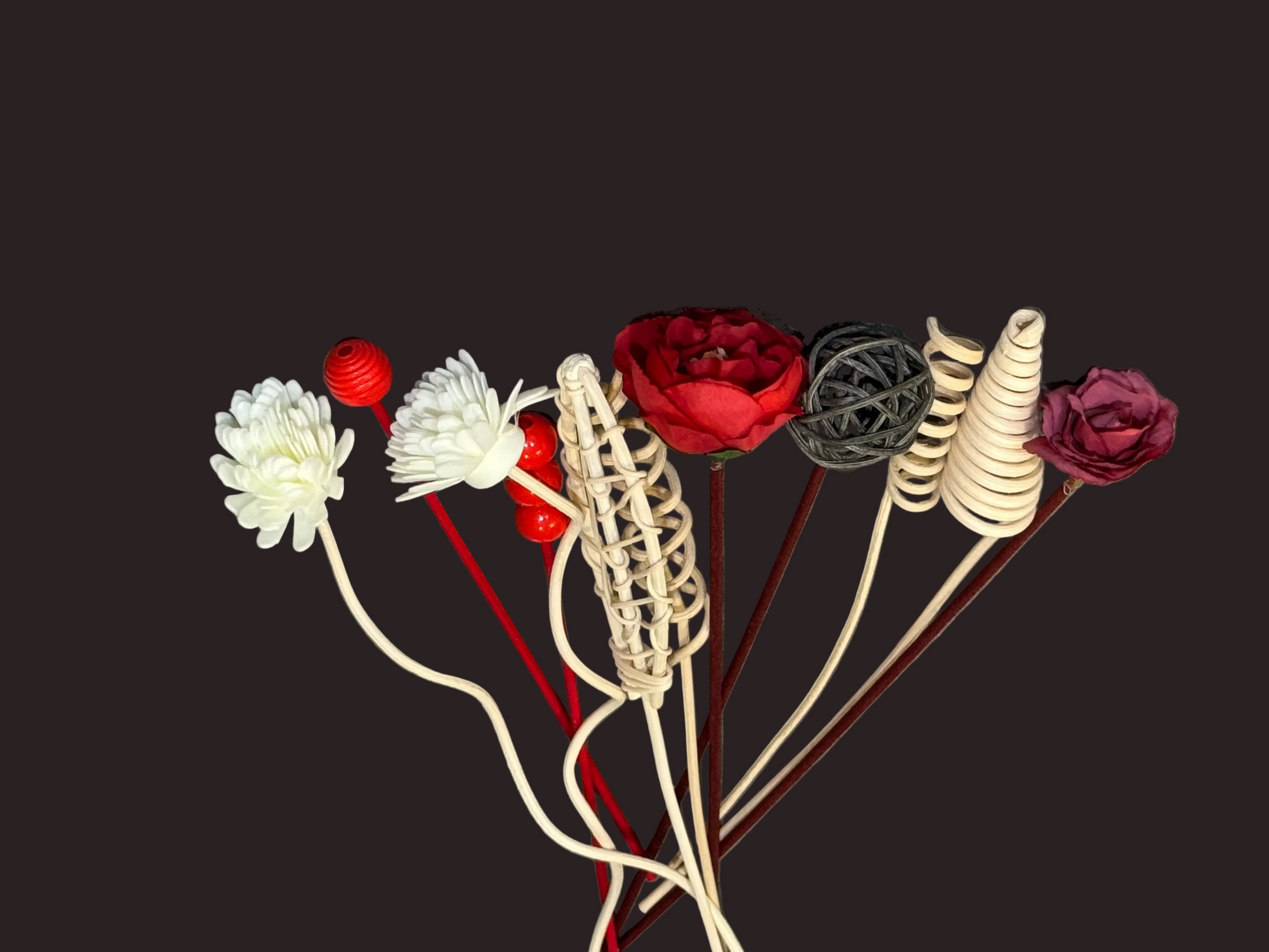 Decorative items including flowers and spherical ornaments for reed diffusers on a gray background