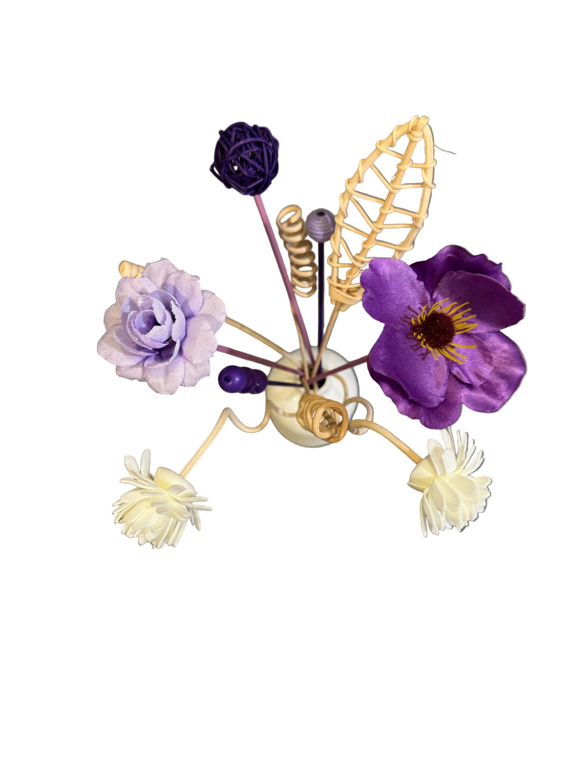Decorative flower arrangement with a small vase on a reflective surface. Reed diffuser bouquet.